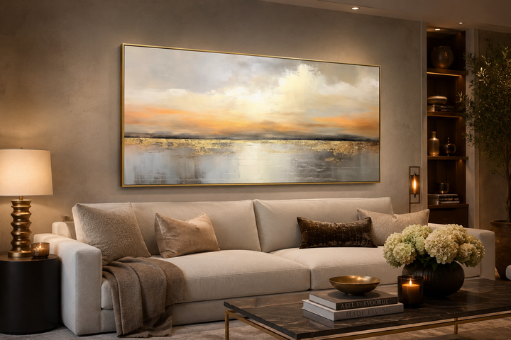 Silver and gold abstract ocean sunset framed canvas wall art hanging above a sofa in a living room.