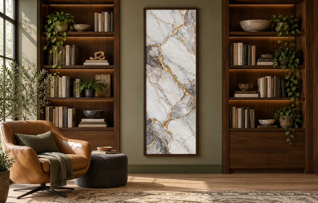 Vertical silver and gold marble wall art in a tall slim frame between two walnut bookshelves.