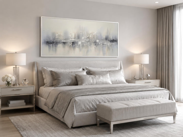 Silver grey and white abstract wall art in a horizontal frame above a bed in a neutral bedroom.