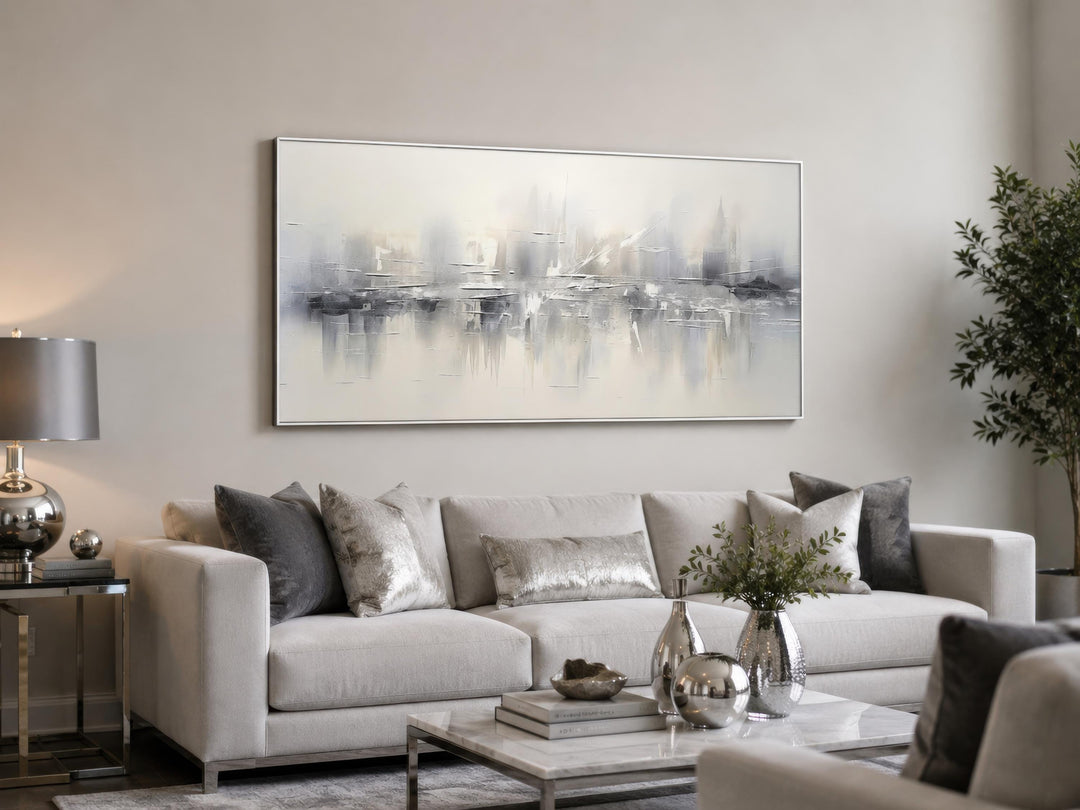 Silver grey and white abstract horizontal canvas wall art hanging above a sofa in a living room.
