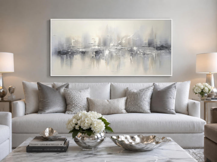 Silver grey and white abstract wall art hanging above a white sofa in a modern living room.