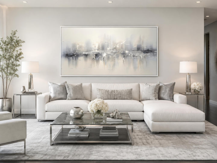 Silver grey and white abstract canvas wall art hanging above a white sectional sofa.