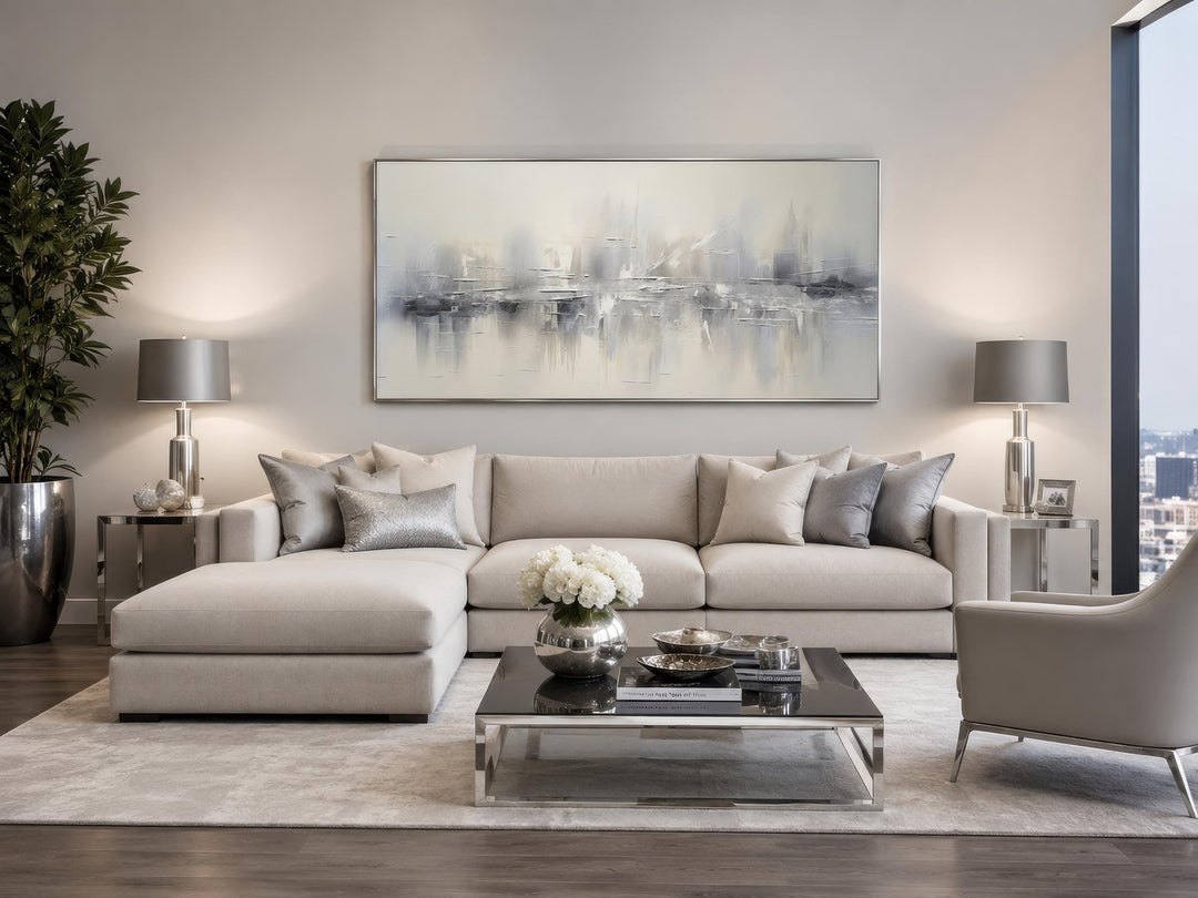 Silver grey and white abstract wall art hanging above a neutral sectional sofa in a living room.