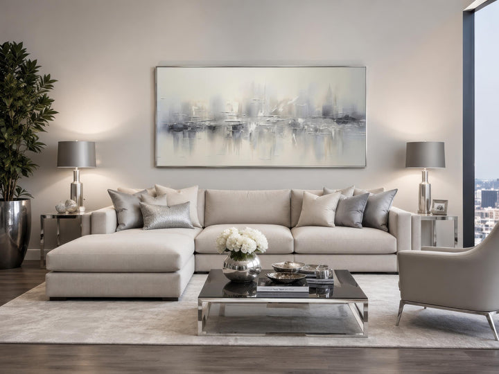 Silver grey and white abstract wall art hanging above a neutral sectional sofa in a living room.