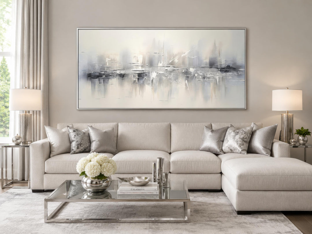 Silver grey and white abstract wall art hanging above a neutral sectional sofa in a living room.