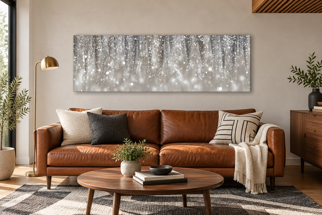 Horizontal abstract rain canvas print in silver and beige tones hanging above a leather sofa.