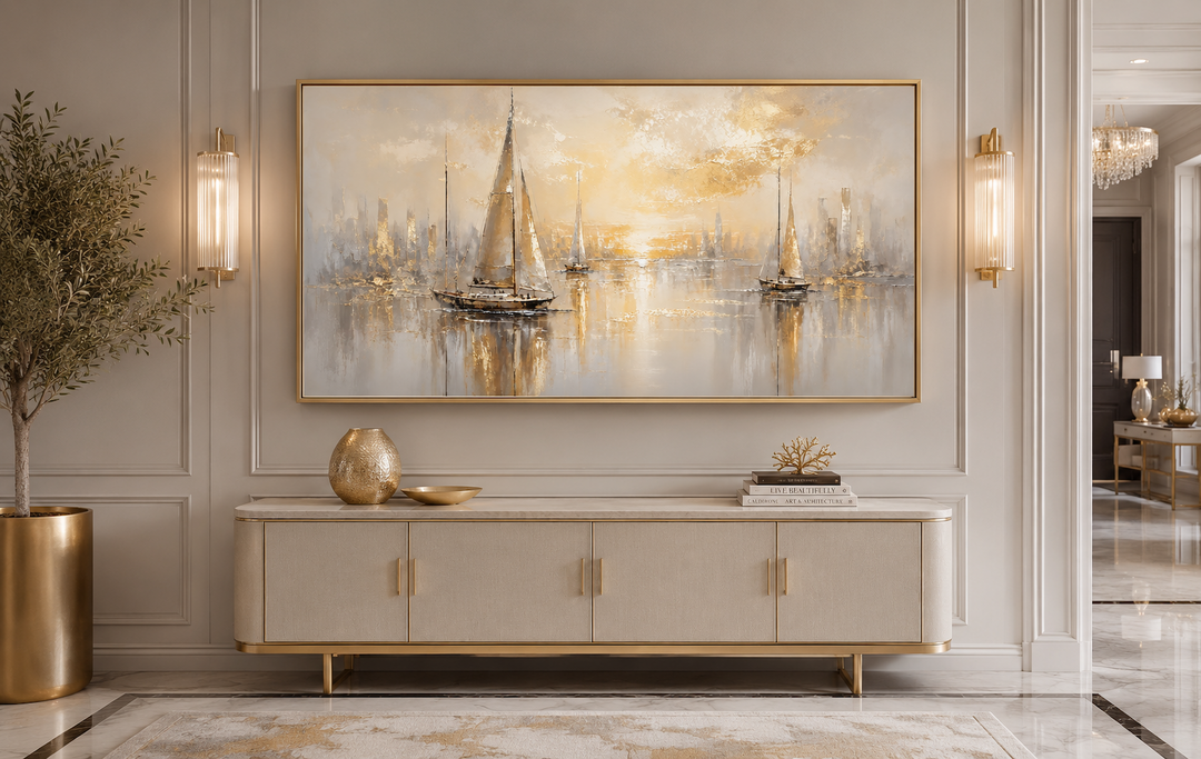 Abstract silver and gold sailboat painting in a gold frame above a modern cream sideboard.