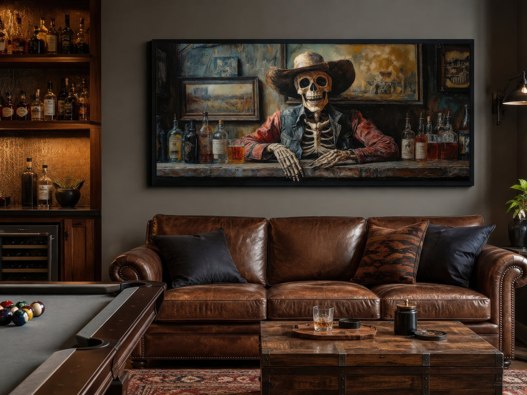 Framed canvas wall art of a skeleton cowboy barman in a saloon above a leather sofa in a home bar.