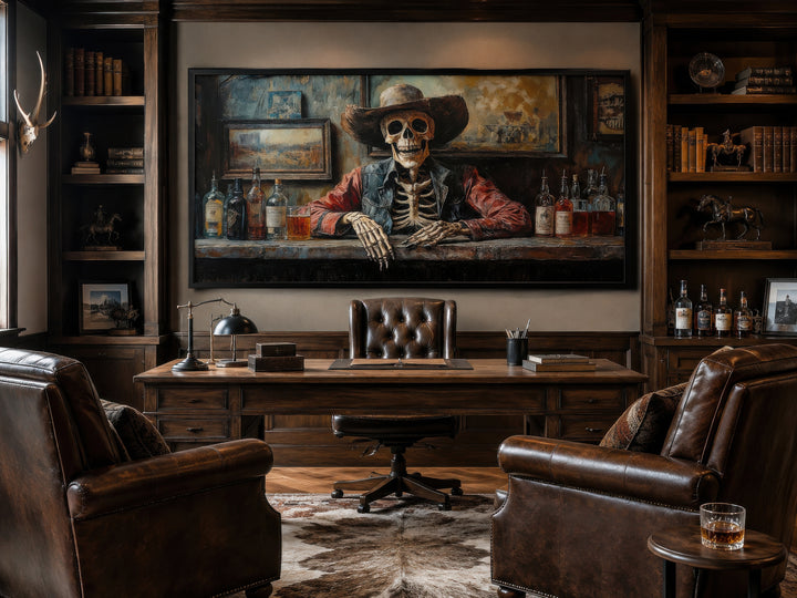 Framed canvas wall art of a skeleton cowboy barman in a saloon, hanging in a rustic home office.
