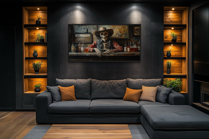 Skeleton cowboy barman framed canvas wall art hanging above a dark sofa in a modern living room.
