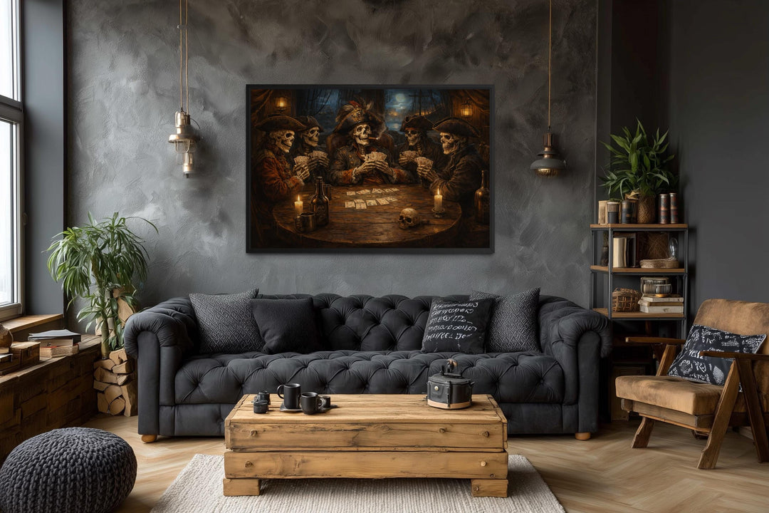 A framed gothic painting of skeleton pirates playing cards hangs in a moody, modern living room.
