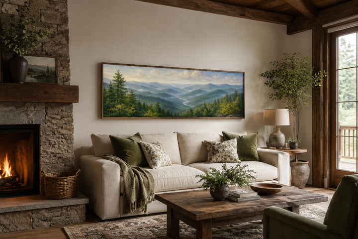 Panoramic Smoky Mountains wall art above a sofa in a rustic living room with a stone fireplace.