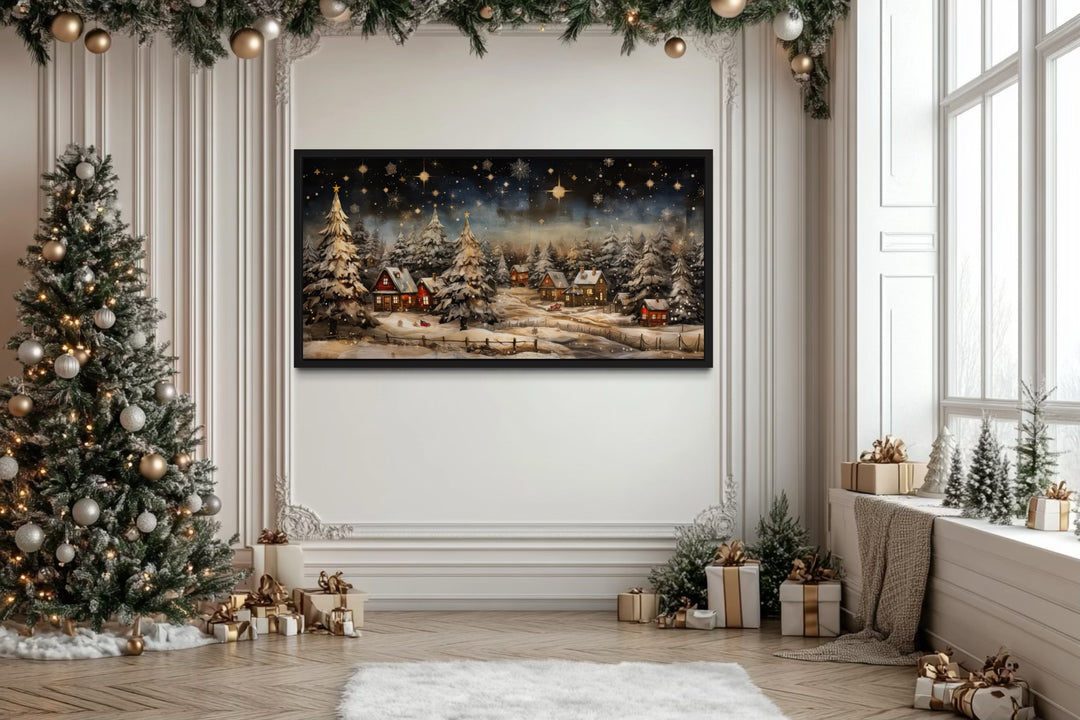 Snowy winter village at night wall art in a festive room with a Christmas tree and gifts.