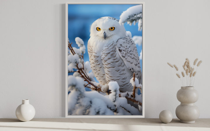 Framed canvas wall art of a snowy owl perched on snow-covered branches in a winter landscape.