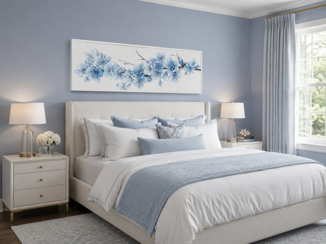 Long horizontal wall art with soft blue blossom flowers hanging above a bed in a blue bedroom.