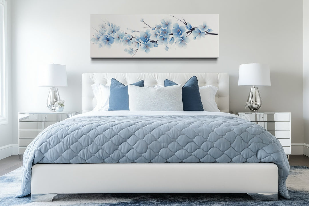 Soft blue blossom flowers long horizontal canvas wall art hanging above a bed in a modern bedroom.