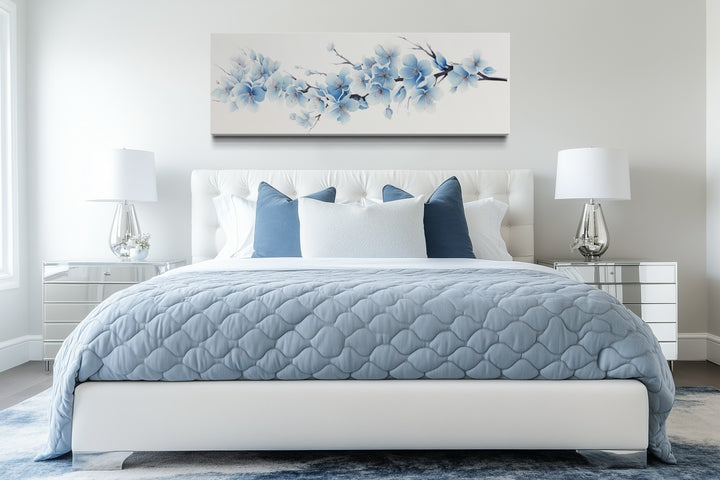 Soft blue blossom flowers long horizontal canvas wall art hanging above a bed in a modern bedroom.