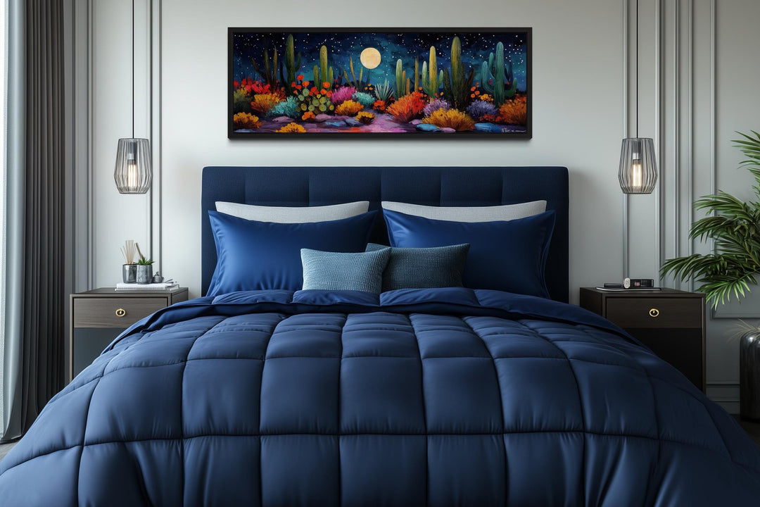 Southwest desert cacti under a moon and starry sky long horizontal canvas wall art above a bed.