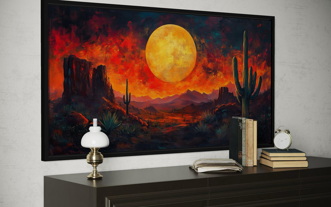 Southwest desert wall art featuring a dramatic red sunset and cactus silhouette in a black frame.