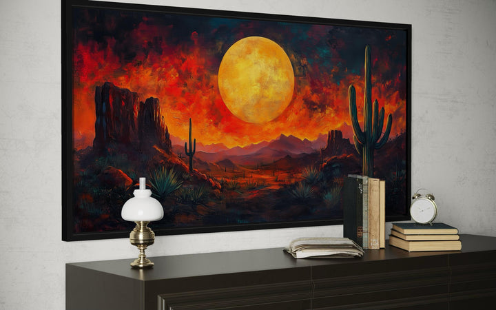 Southwest desert wall art featuring a dramatic red sunset and cactus silhouette in a black frame.