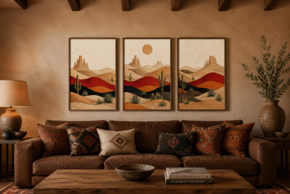 Triptych of mid-century modern southwest desert landscape canvas prints above a brown leather sofa.