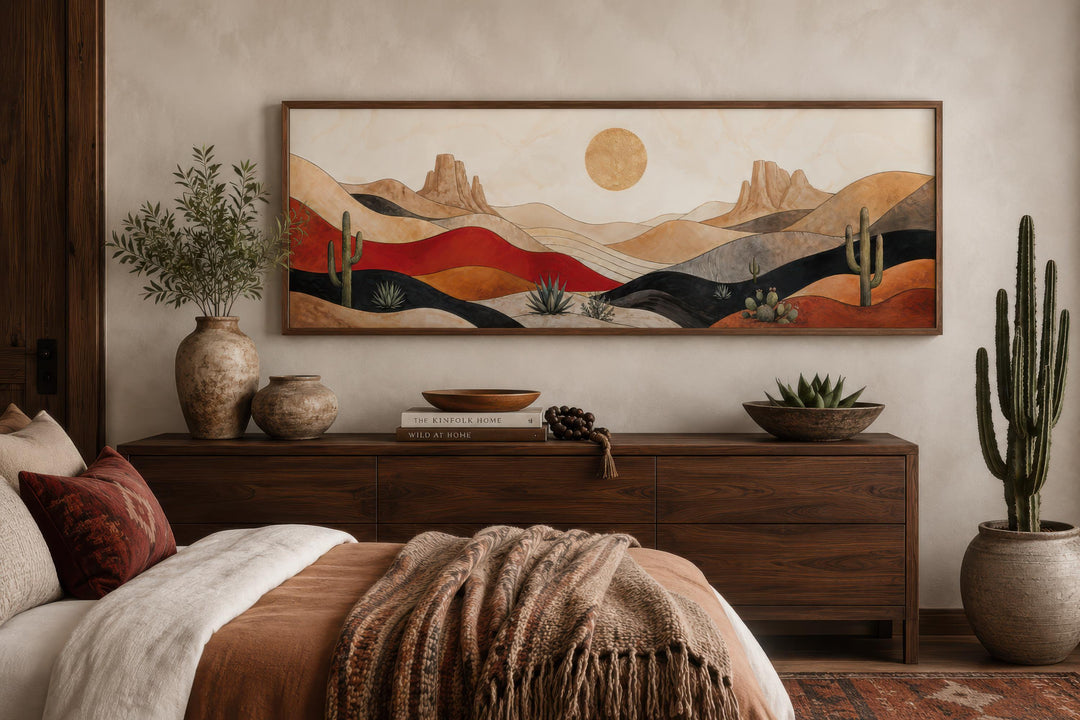 Southwest desert landscape wall art with cactus and golden sun above a dark wood dresser.