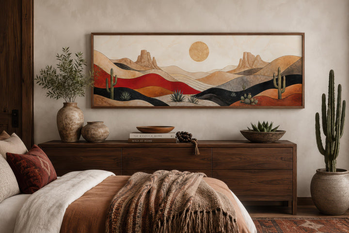 Southwest desert landscape wall art with cactus and golden sun above a dark wood dresser.