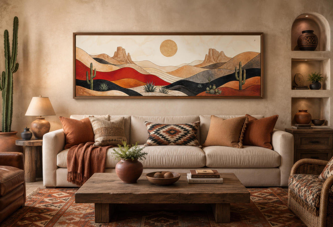 Southwest desert landscape canvas print with cactus and sun above a sofa in a warm living room.