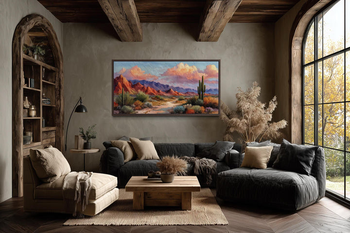A rustic horizontal canvas print of a vibrant Southwest desert landscape hangs in a cozy room.