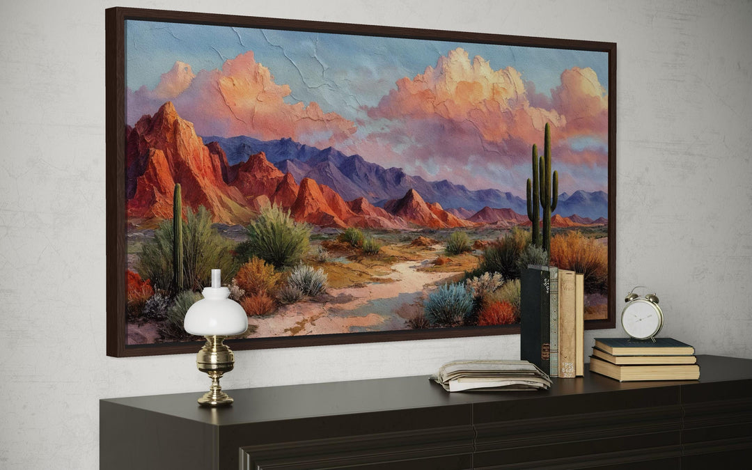 A framed horizontal canvas print of a vibrant Southwest desert landscape with mountains and cacti.