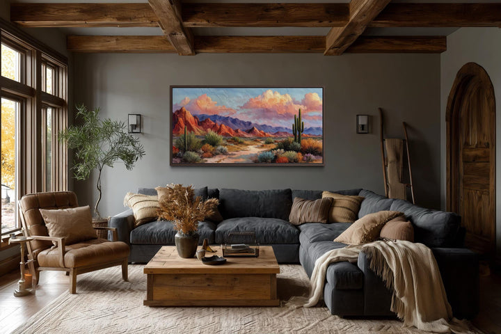 A rustic horizontal canvas print of a vibrant Southwest desert landscape hangs in a cozy living room.