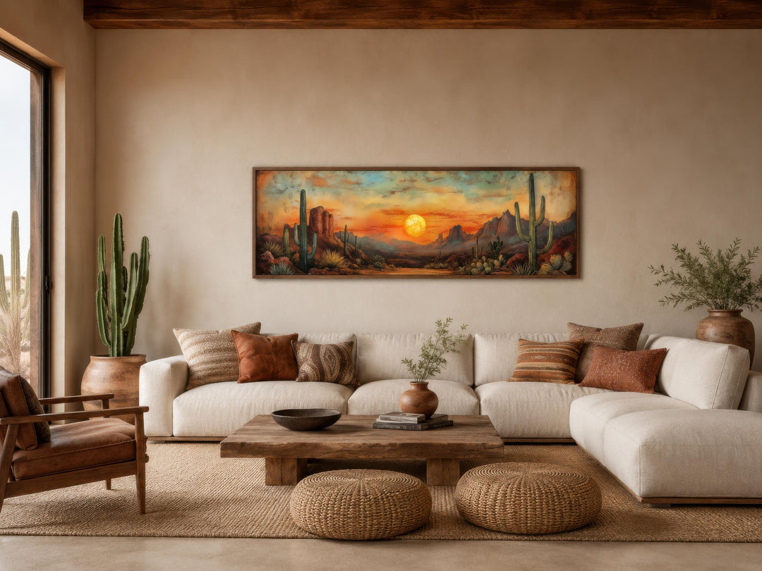Panoramic Southwestern wall art of a desert sunset with saguaro cacti above a modern white sofa.