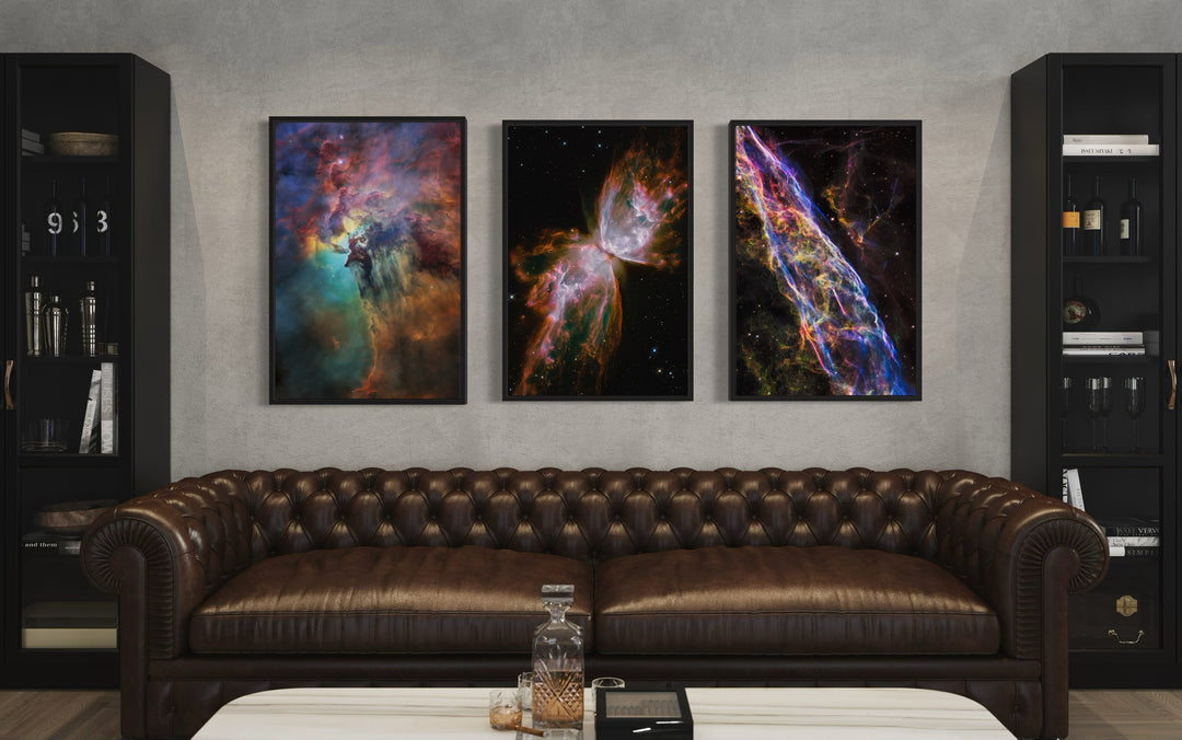 Set of 3 framed Hubble Telescope nebula photographs displayed above a brown leather sofa.