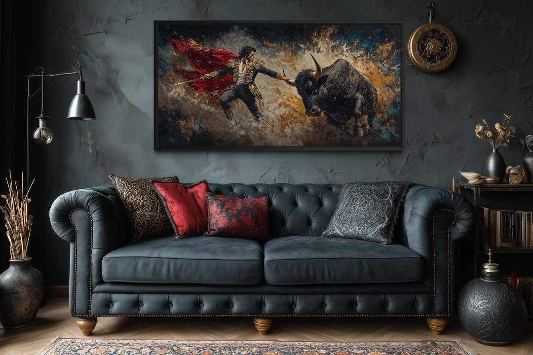 Spanish matador fighting a bull canvas wall art displayed above a dark blue tufted sofa.