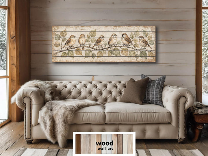 Sparrows on Birch Tree Branch distressed wood wall art displayed above a tufted sofa.