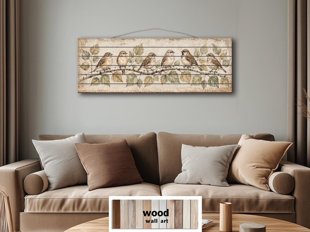 Sparrows on Birch Tree Branch distressed wood wall art hanging above a neutral-toned sofa.