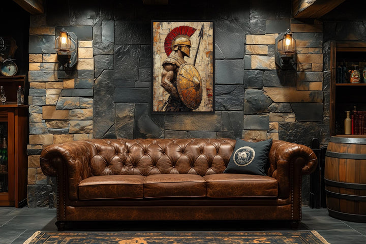 Spartan warrior canvas wall art with spear and shield above a brown leather sofa in a stone room.