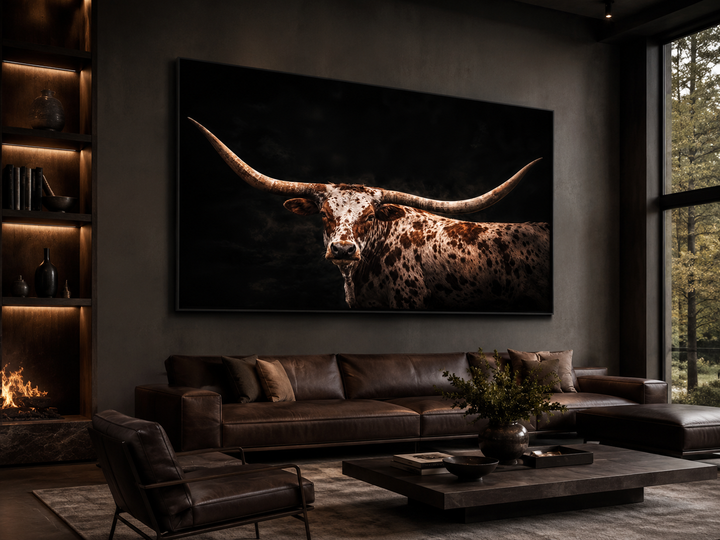 Spotted Texas Longhorn canvas print with floating frame above a leather sofa in a rustic room.