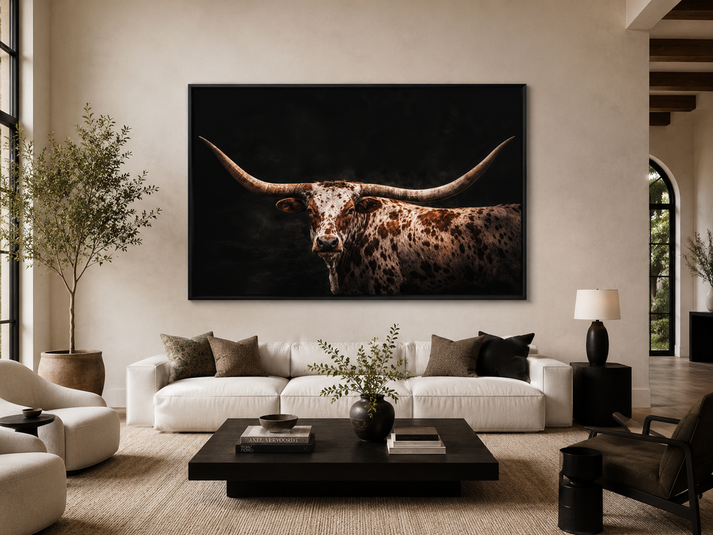 Spotted Texas Longhorn wall art canvas print with a black floating frame in a modern living room.