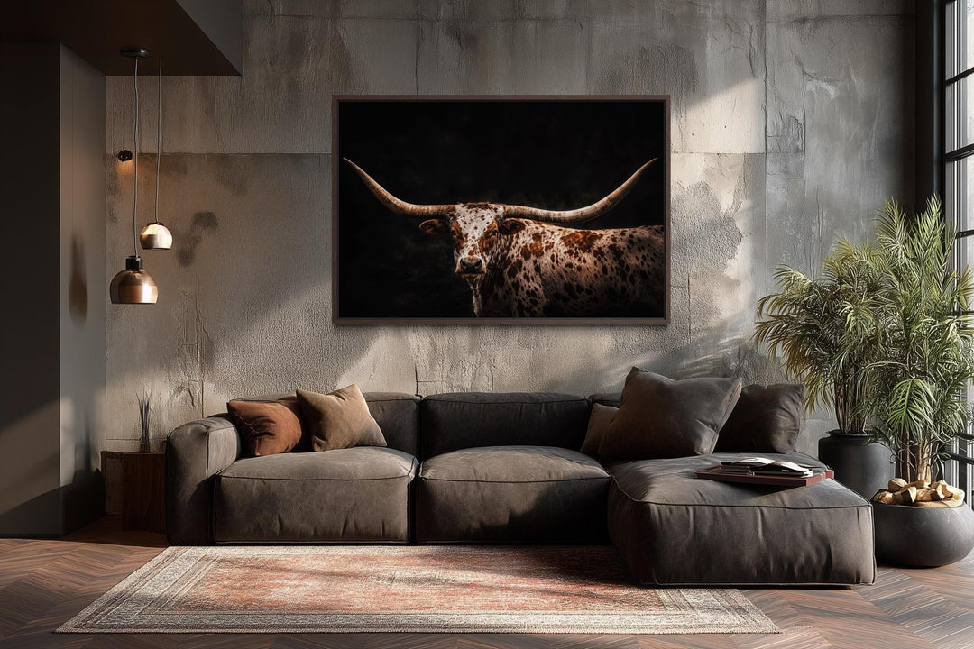 Spotted Texas Longhorn canvas print with a dark background in a rustic living room setting.