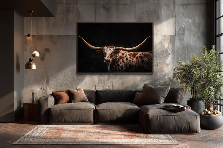 Spotted Texas Longhorn canvas print with a dark background in a rustic living room setting.