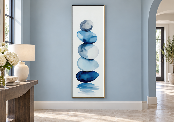 Tall narrow framed canvas wall art featuring navy blue and white watercolor stacked rocks.