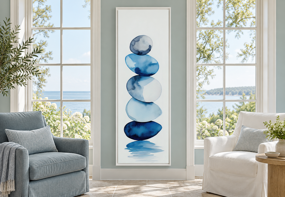 Tall narrow framed canvas wall art featuring navy blue watercolor stacked rocks in a sunroom.