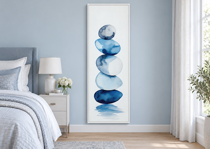 Tall narrow framed canvas wall art featuring stacked navy blue and white watercolor rocks.