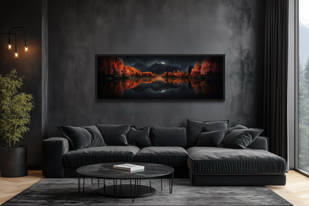 Panoramic wall art of a starry night sky and autumn trees reflected in a mirror lake above a sofa.