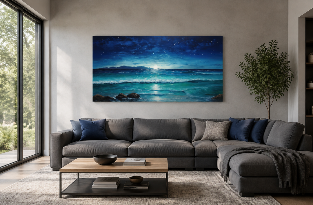 Panoramic framed canvas of a starry night sky over ocean waves above a modern grey sectional sofa.