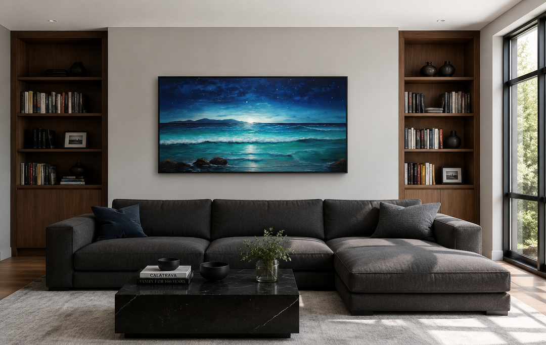 Framed panoramic canvas art of a starry night over ocean waves above a dark grey sectional sofa.