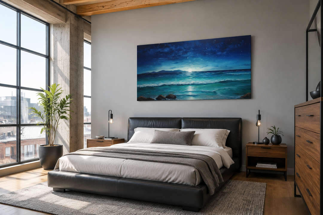 Framed panoramic canvas of a starry night over ocean waves above a modern black leather bed.