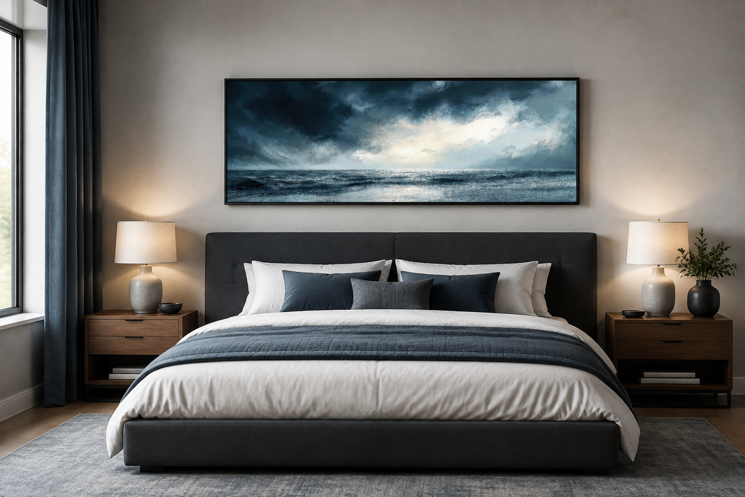 Stormy horizon over the ocean panoramic canvas wall art hanging above a dark gray upholstered bed.