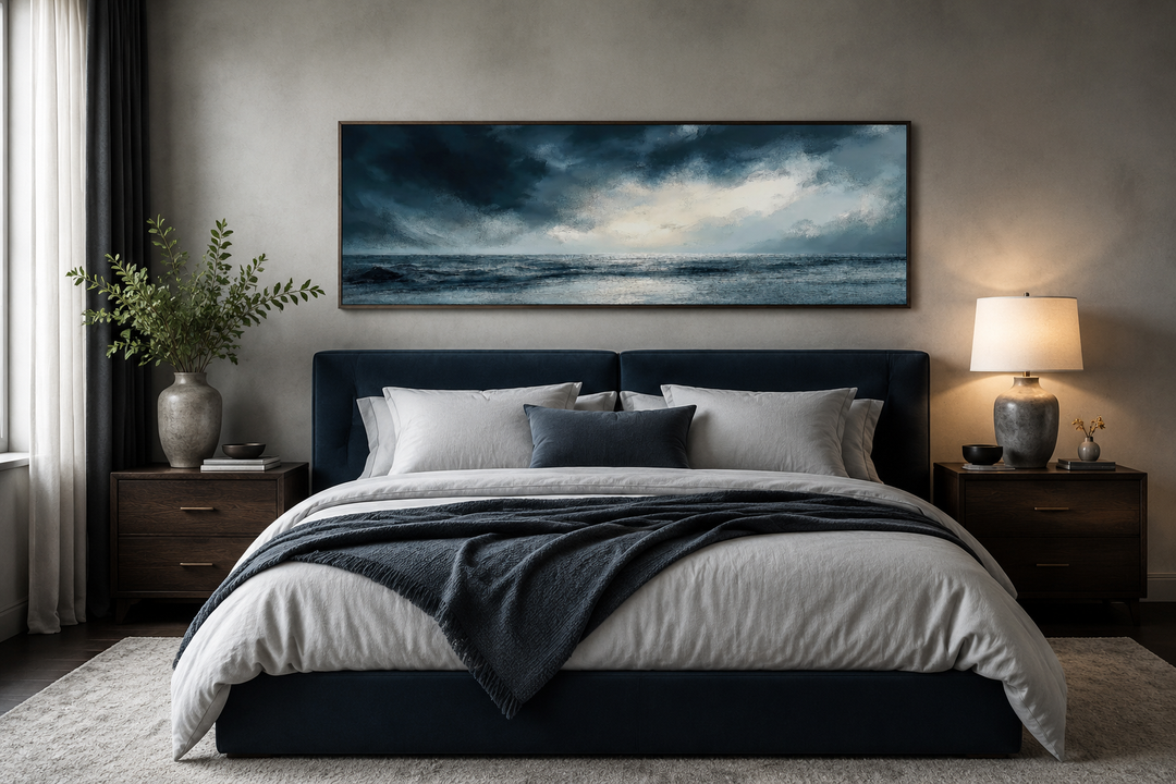 Stormy horizon over the ocean panoramic canvas wall art hanging above a navy blue bed.